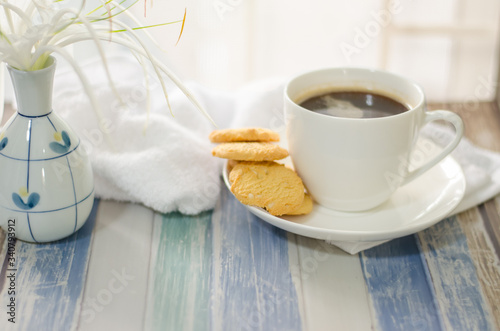 Cup of hot coffee with .butter cookies and flower on a wooden table holiday home vacation ideas