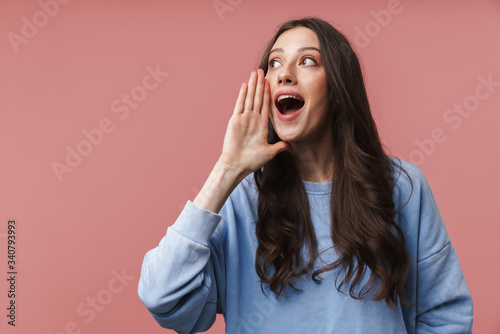 Image of young woman screaming or calling with hands at her mouth