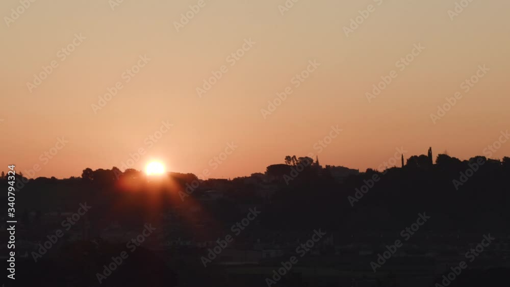 Sunrise timelapse of how the sun appears behind a forest, showing awesome colors Sunrise timelapse of how the sun appears behind a forest, showing awesome colors