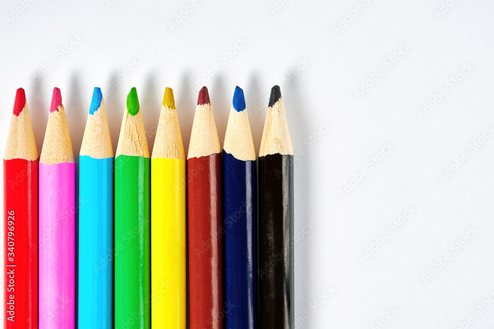 Rainbow colorful pencils in a row on the white paper, flat lay background. Copy space for your text Rainbow colorful pencils in a row on the white paper, flat lay background. Copy space for your text