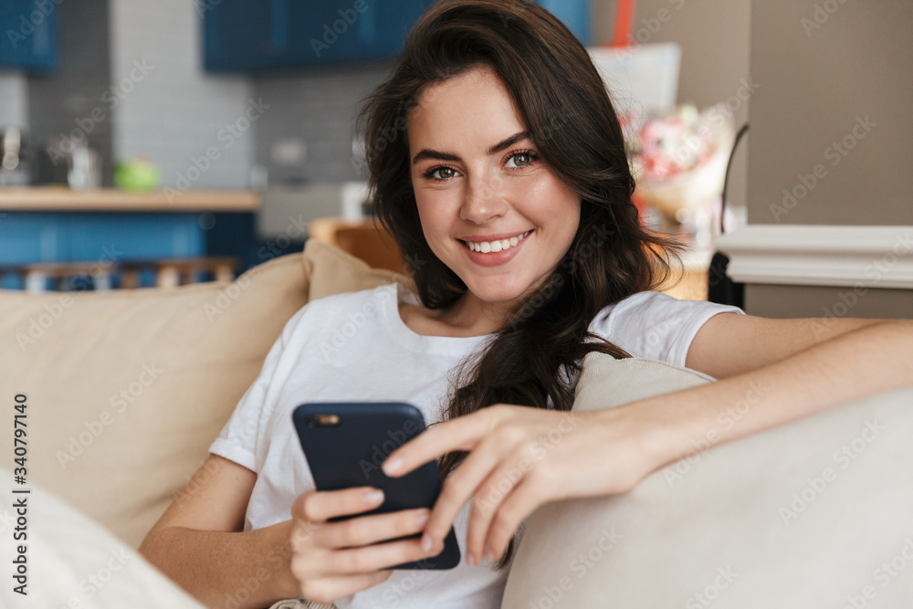 Beautiful young brunette woman relaxing on a couch at home Beautiful young brunette woman relaxing on a couch at home