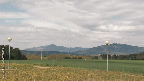 Timelapse of the movement of clouds and their shadows in a small town in Barcelona. In the background are some mountains photo