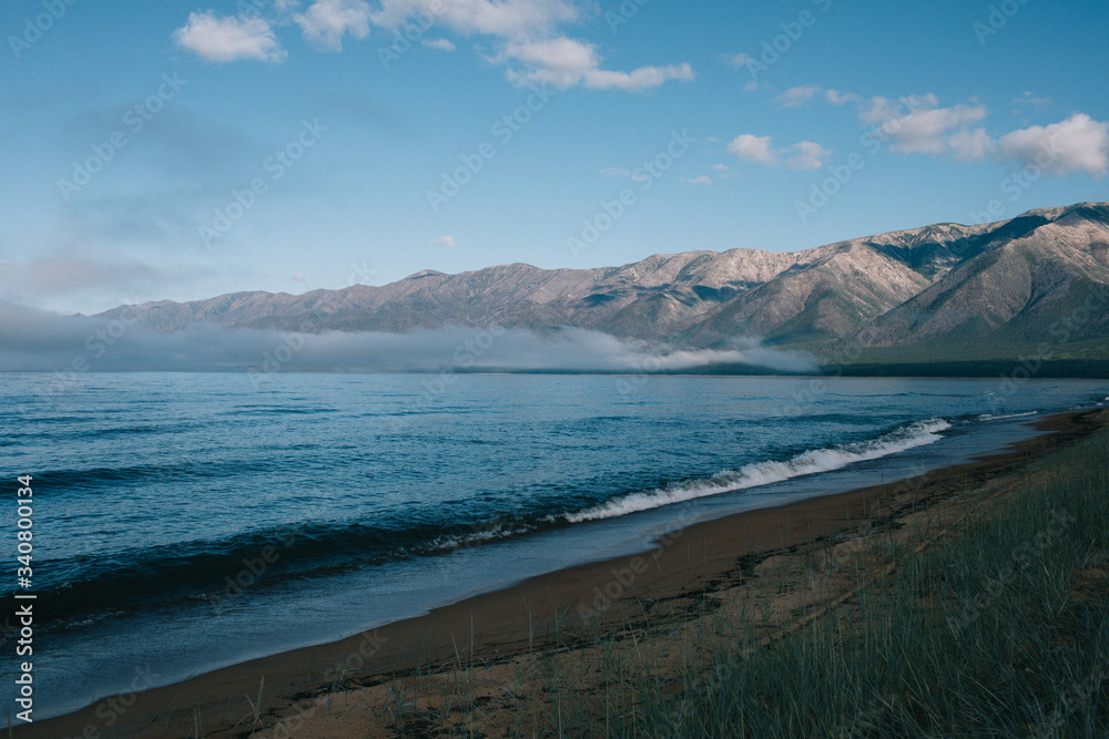 A body of water with a mountain in the background