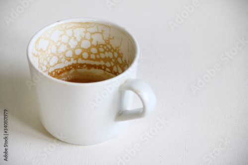 dirty empty coffee cup closeup on white table. top view empty and dirty cup of coffee on a white background