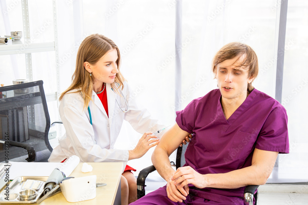 Obraz premium The female doctor to the syringe for injecting the patient in the examination room.