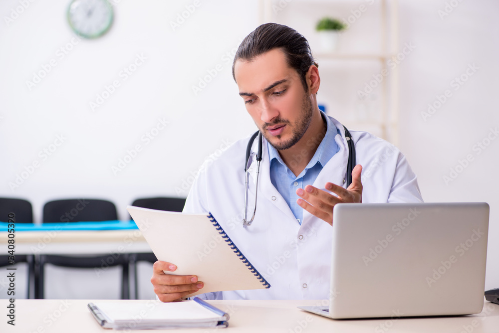 Young handsome male doctor working in the clinic