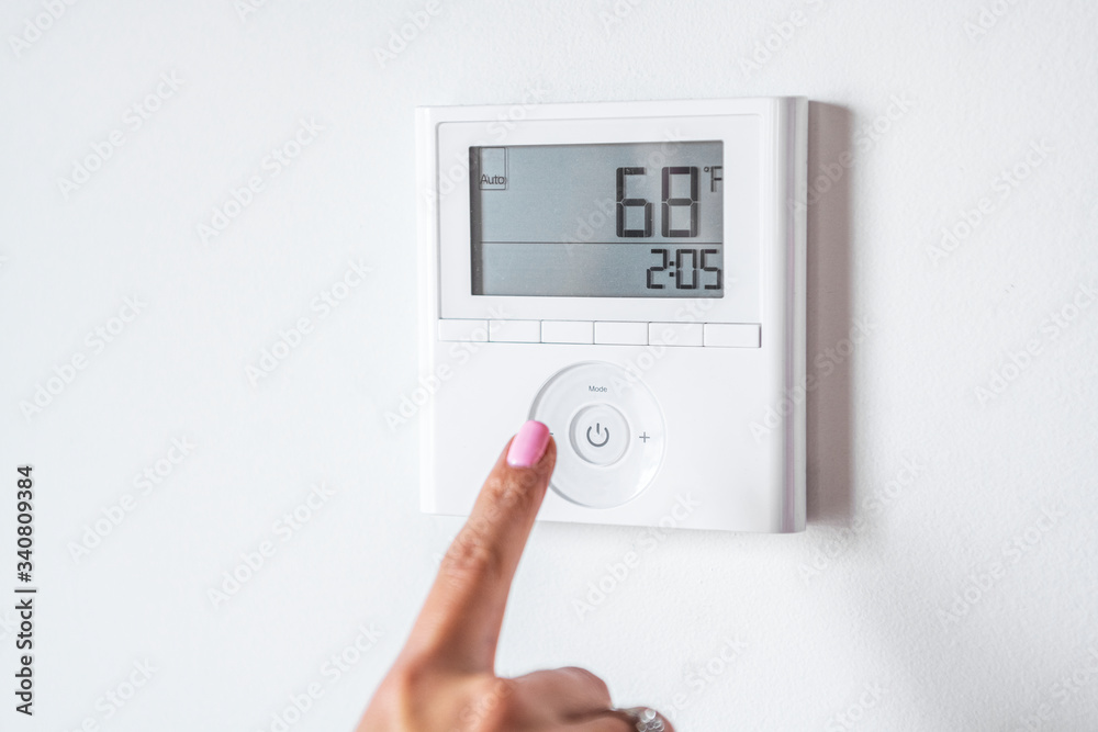 Man adjusting the thermostat Man adjusting the thermostat