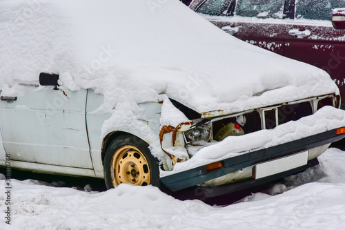Obraz na płótnie Fragment of a white broken car covered with snow close-up w salonie