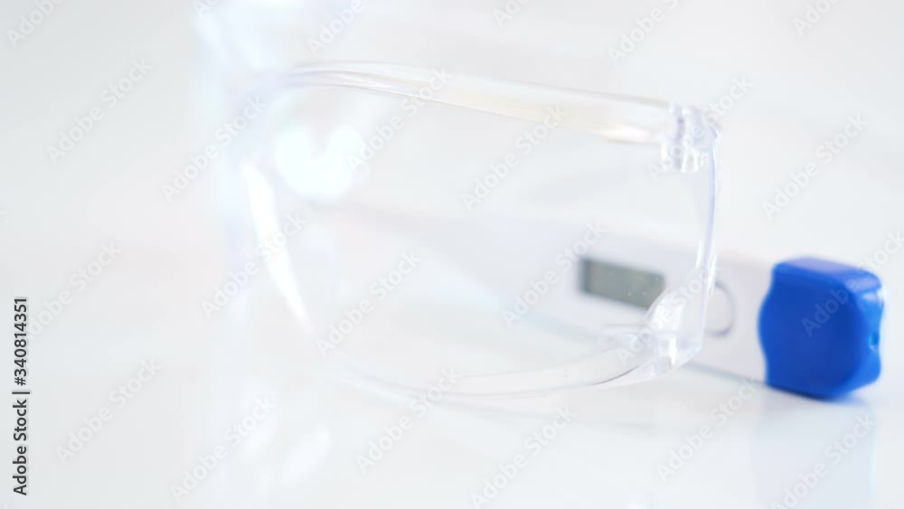 A clear eyeglass and a thermometer on the table A clear eyeglass and a thermometer on the table