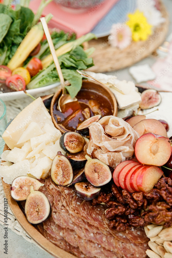 A close up of a charcuterie plate set up outside for an al fresco feast A close up of a charcuterie plate set up outside for an al fresco feast