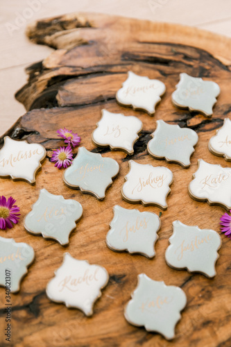 Calligraphed place cards for dinner arrranged on a wooden plank