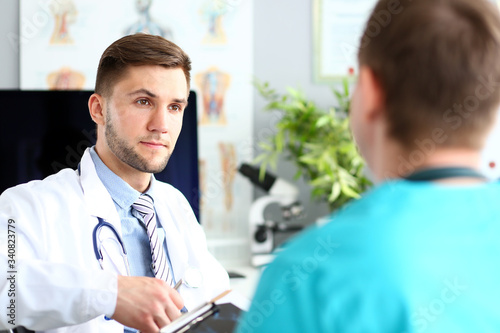 Portrait of doc man having dialogue with specialist. Physician wearing classy blue shirt white robe and striped tie. Medical treatment and healthcare concept