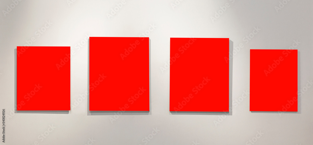 Four empty isolated on red paintings on the wall with gallery lighting. Space for text.