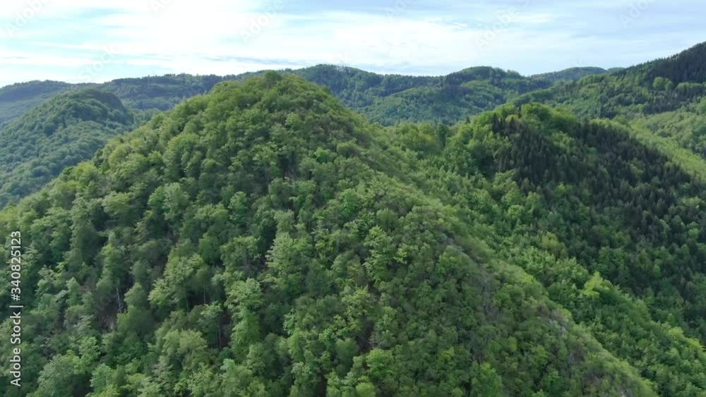 Wide angle dolly in drone shot of beautiful mountains and hills in Suhi Potok settlement in the Municipality of Kocevje in southern Slovenia Wide angle dolly in drone shot of beautiful mountains and hills in Suhi Potok settlement in the Municipality of Kocevje in southern Slovenia