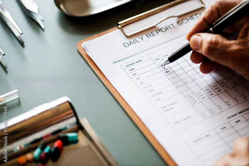 Closeup of doctor checking patient daily report checklist Closeup of doctor checking patient daily report checklist