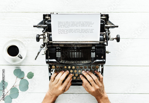 Aerial view of a man typing on a retro typewriter photo