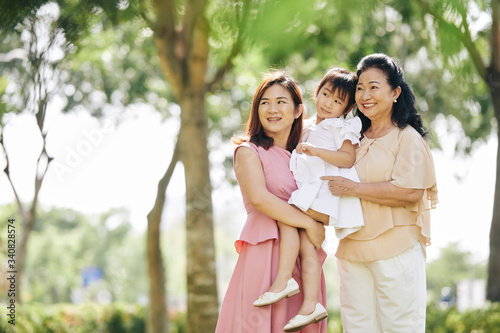 Portrait of Vietnamese three generations of women spending time in city park