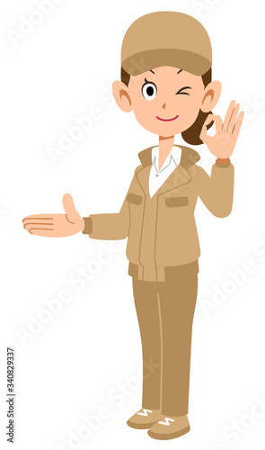 右側を紹介しOKのサインを示すベージュ色の作業着を着た女性
