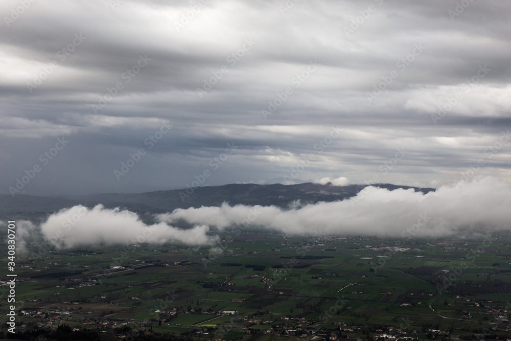 View from above of Umbria valley, with clouds above and below the viewer.
