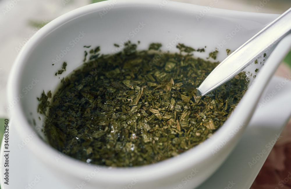 Side view of fresh traditional homemade mint sauce ready for roast lamb. Side view of fresh traditional homemade mint sauce ready for roast lamb.