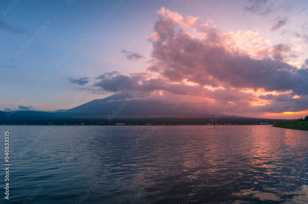 Sunset lake landscape with mount Fuji in the clouds on the background