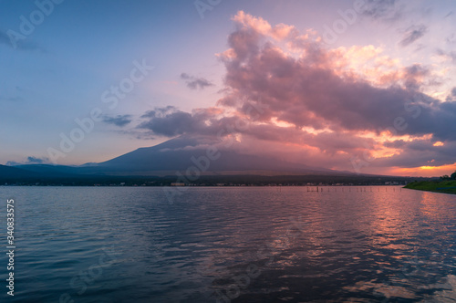 Sunset lake landscape with mount Fuji in the clouds on the background