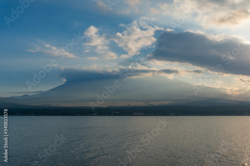 Lake landscape with mount Fuji in the clouds on the background