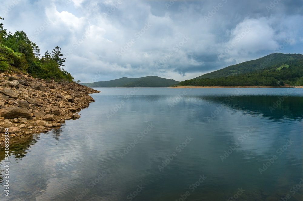 Mountain lake landscape. Nozori lake, dam surrounded by mountains Mountain lake landscape. Nozori lake, dam surrounded by mountains