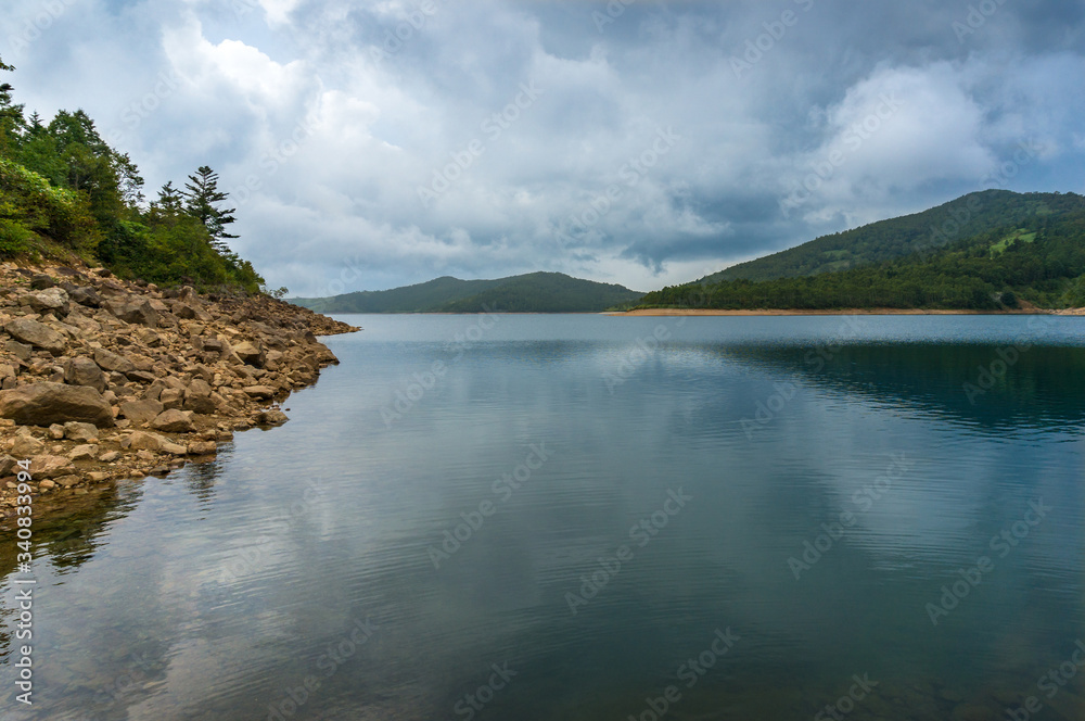 Mountain lake landscape. Nozori lake, dam surrounded by mountains