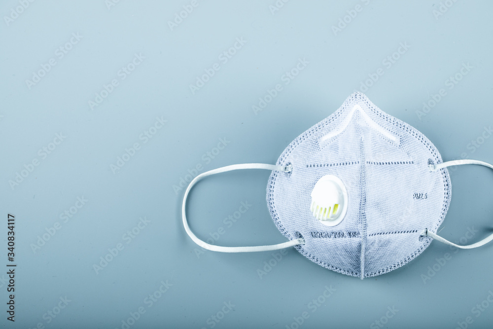 A blue medical face mask on blue background A blue medical face mask on blue background