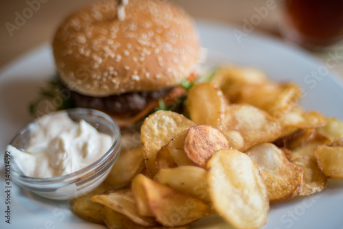 Close up of burger and french fries with sauce served on a plate