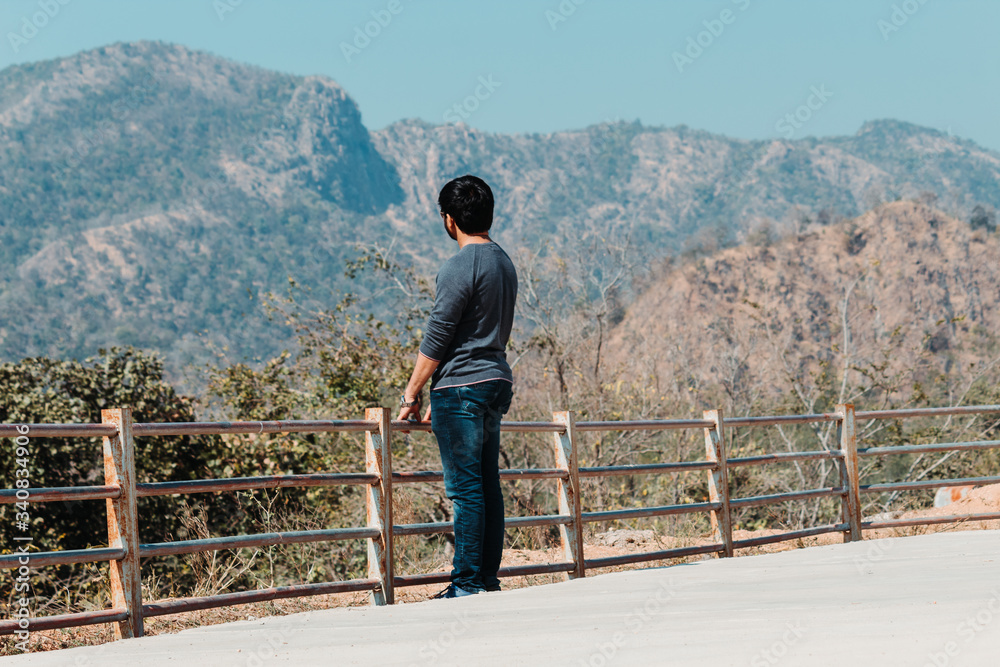 Indian male tourist standing in front of the mountains at Polo Forest in Gujarat, India