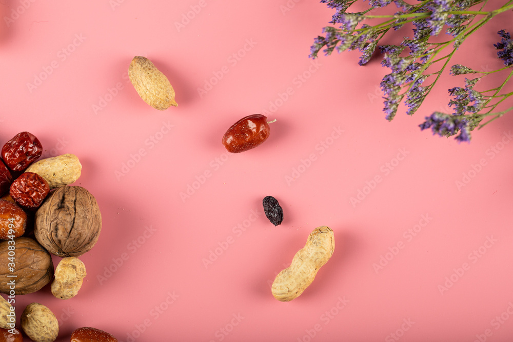 Traditional Novruz holiday nuts isolated on pink background decorated with flowers