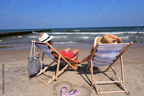 Summer camp. Relaks na plaży nad morzem podczas wakacji letnich, zakochani w walentynki trzymają się za ręce