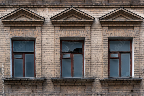 Fragment of the facade of an abandoned 19th century building with three windows
