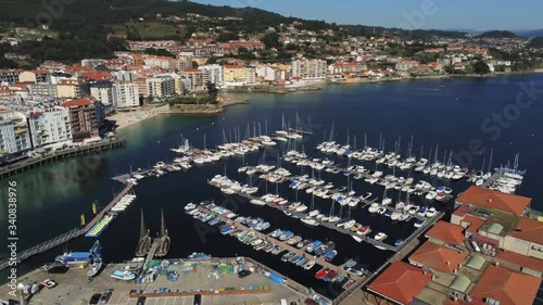 4k Cinematic Areal View of Sanxenxo Beach and Marina with Boat anchored. Summer Holiday destination in Spain, Galicia. photo