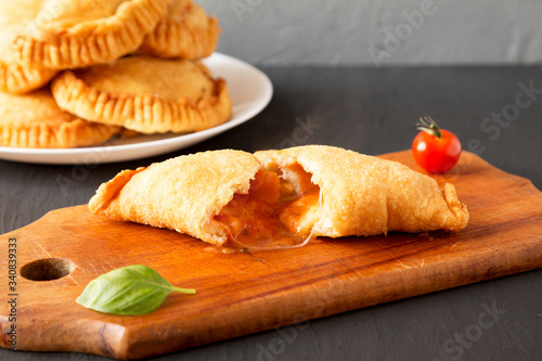 Homemade Deep Fried Italian Panzerotti Calzone with sauce, side view. Close-up. photo