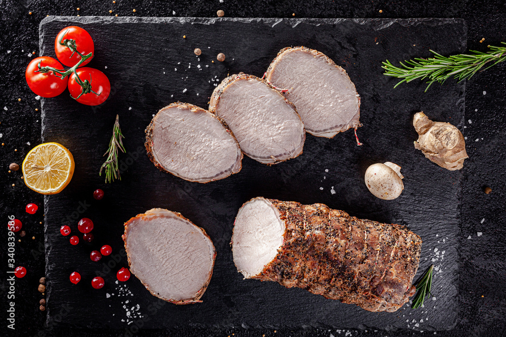 Various sausages and smoked products lie on a black board, sausage, sausages, ribs, rolls. Top view, overhead. Flat lay