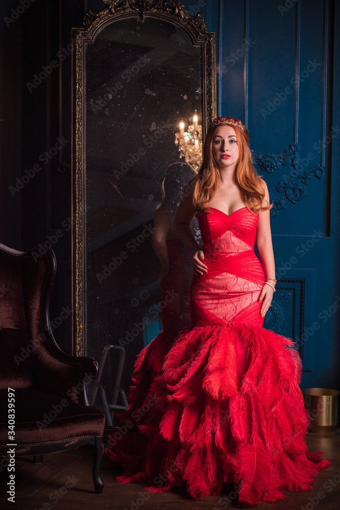 Redhead Woman in red luxury dress with feathers