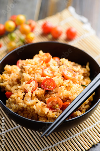 Fried rice with minced pork and tomato in a bowl and chopsticks ready to eating, Asian food