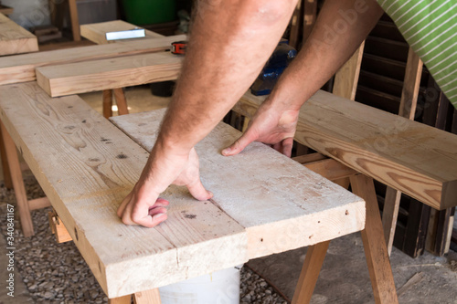 Male carpenter working on old wood in a retro vintage workshop.