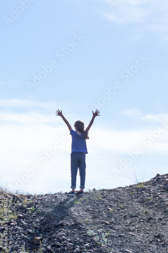 Child girl on the top of the mountain