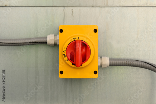 Rotating large red power switch with cables on the sides. photo