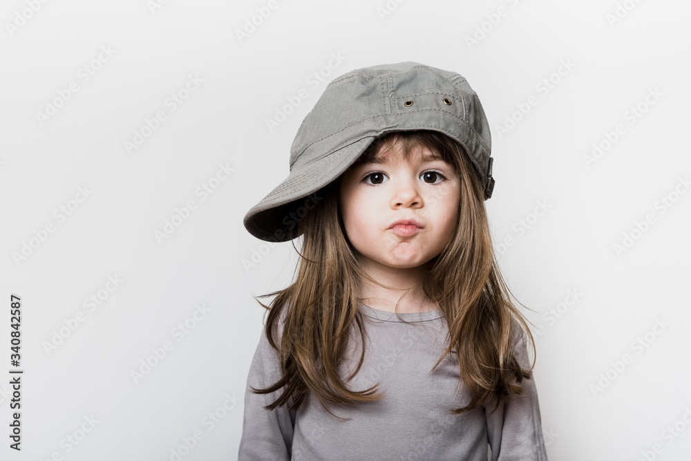 Une petite fille avec une casquette trop grande pour sa tête Stock Photo |  Adobe Stock