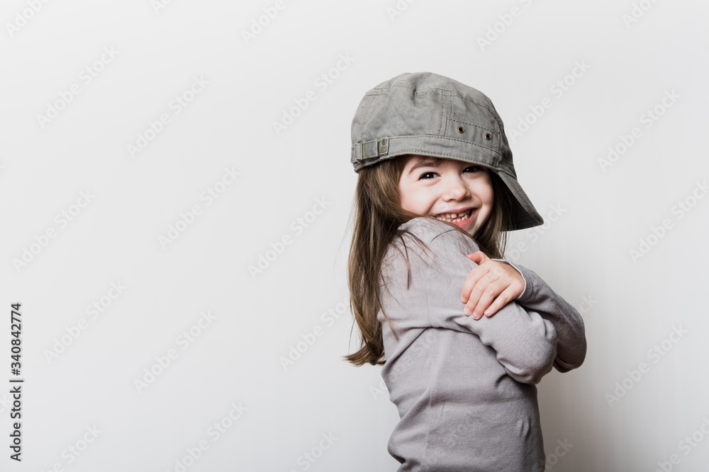 Une petite fille avec une casquette trop grande pour sa tête Photos | Adobe  Stock