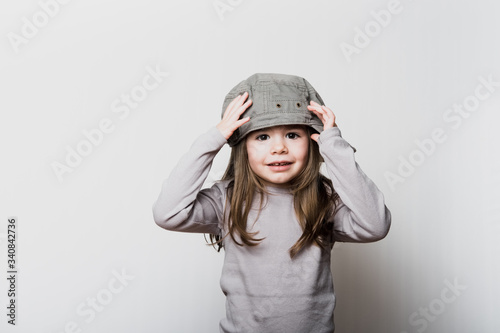 Une petite fille avec une casquette trop grande pour sa tête photo