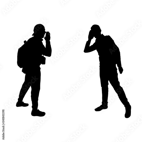 Black silhouette of men.  The man yells for another. The man tries to hear. Understanding people. Teamwork. Tourists, travelers, climbers, adventurers, hiking. Mountain trip.