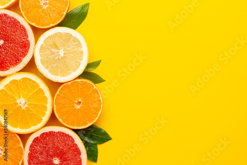 Citruses fruits on yellow background with copyspace, fruit flatlay, summer minimal compositon with grapefruit, lemon, mandarin and orange