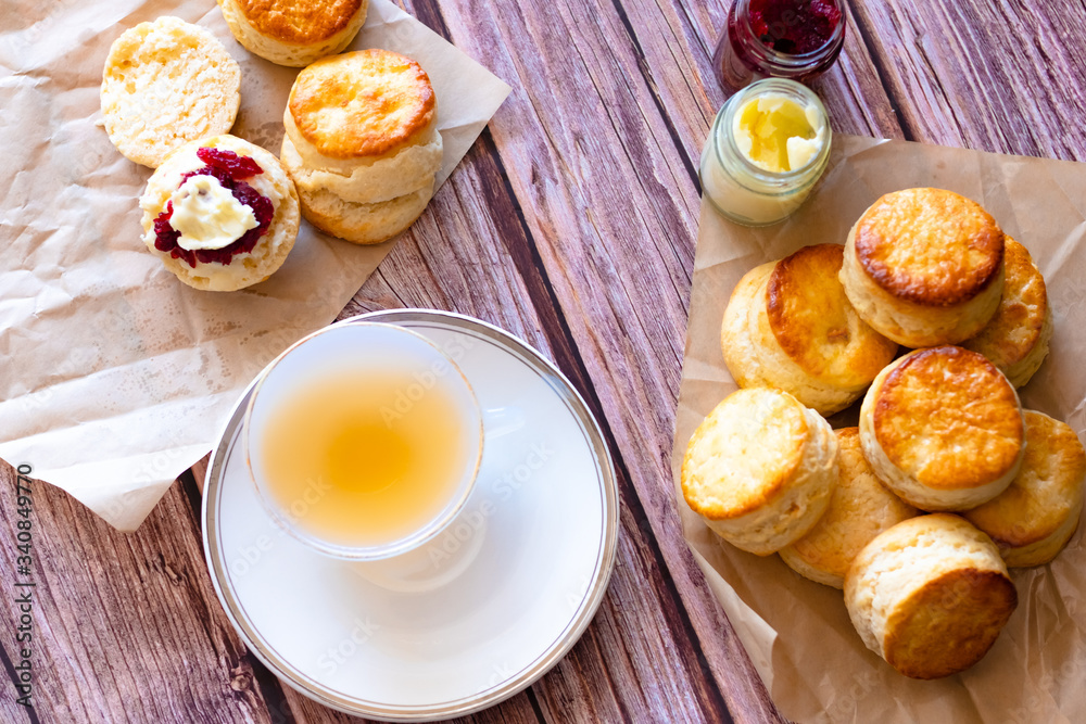 Top view a white cup of tea and Traditional British Scones on wooden table, breakfast food teatime .
