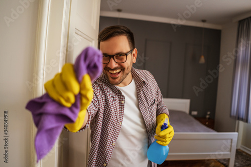 Young man is obsessively cleaning the apartment. photo